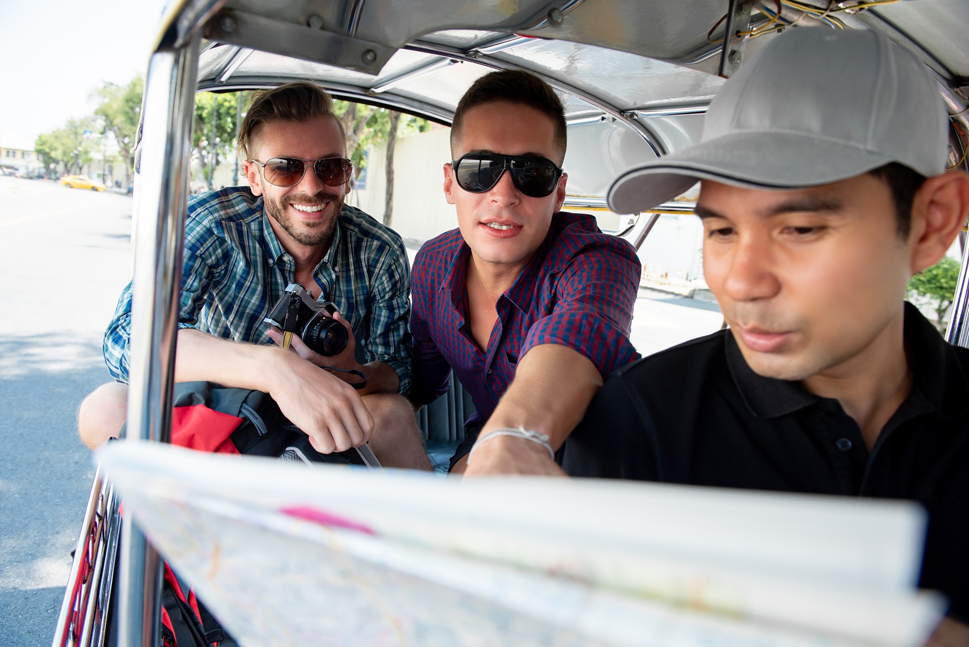 Tourists traveling by local Tuk Tuk taxi in Bangkok Thailand